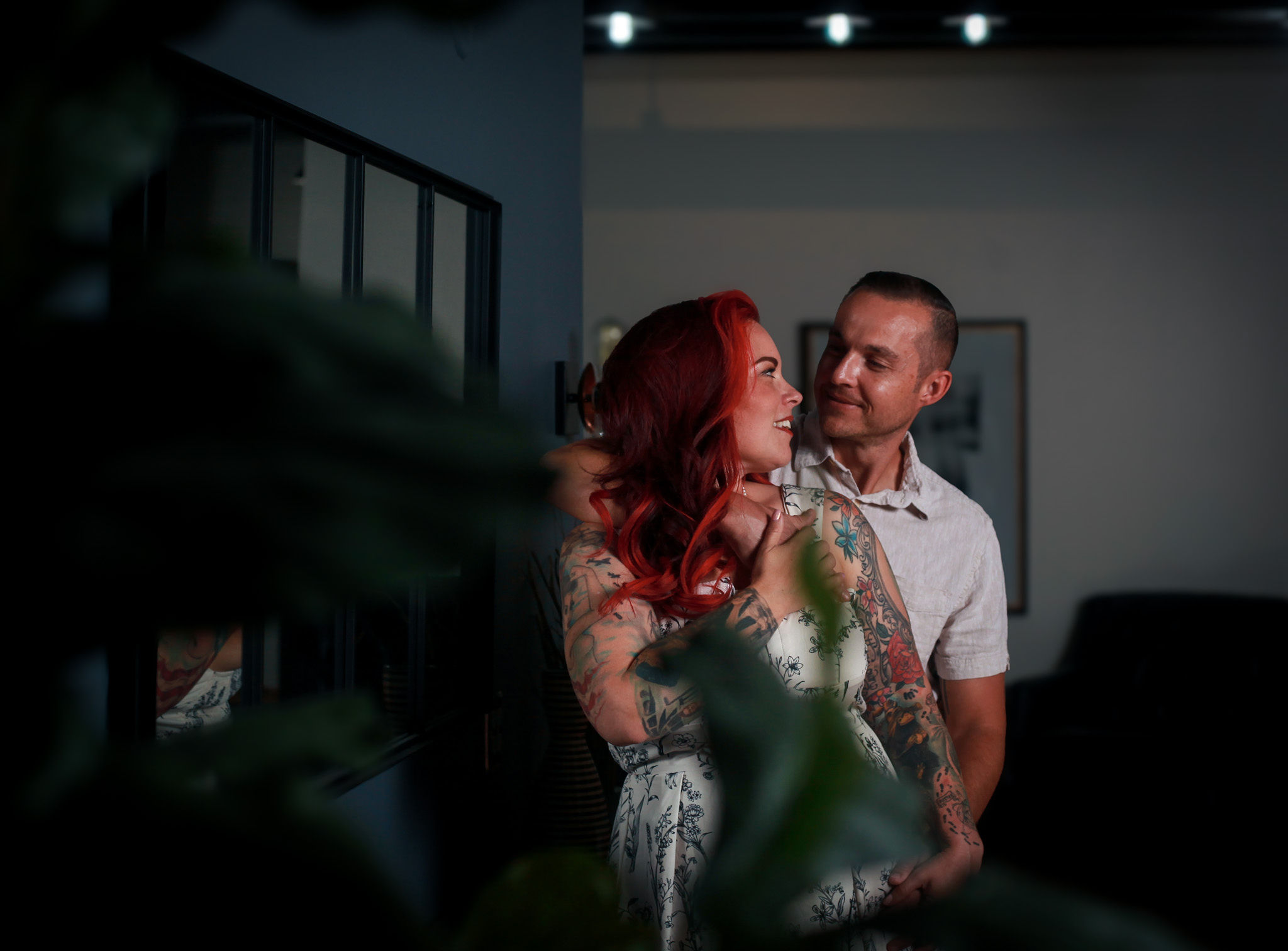 Redhead with partner interacting on blue wall.