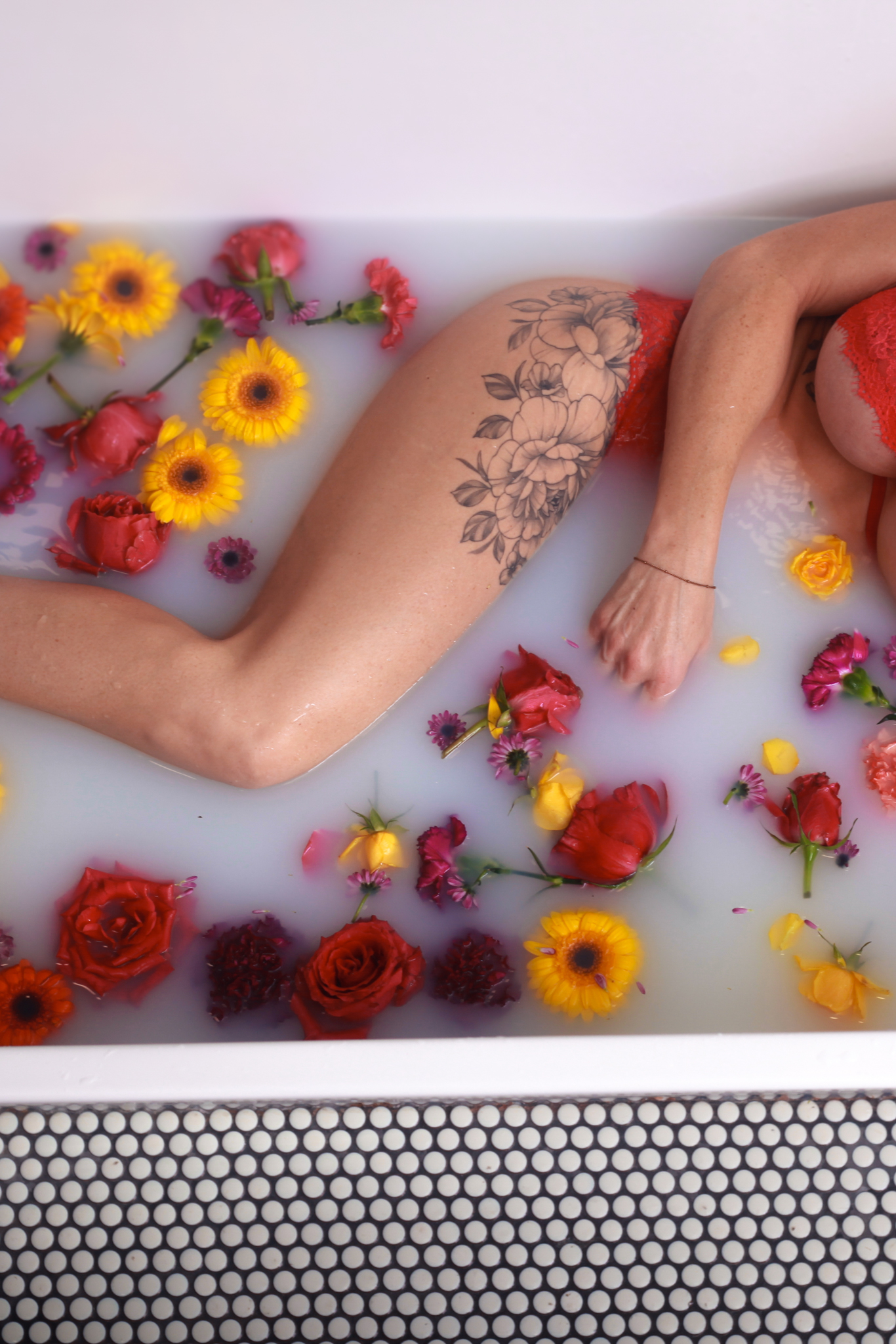 Woman in bathtub with flowers.