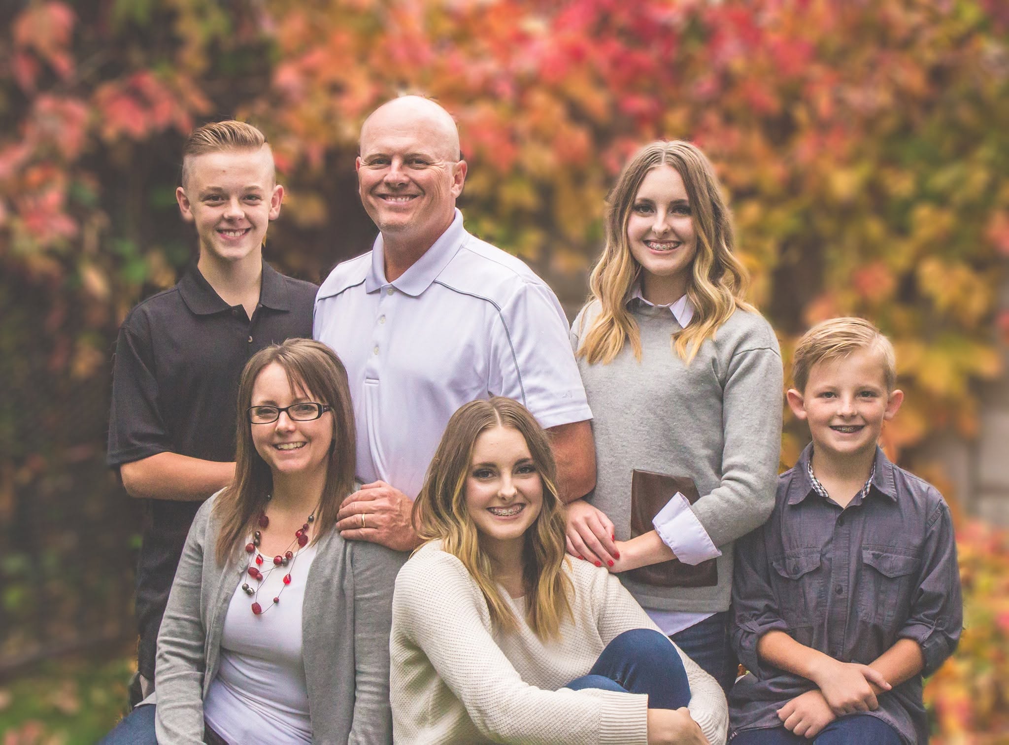 Large family with fall leaves.