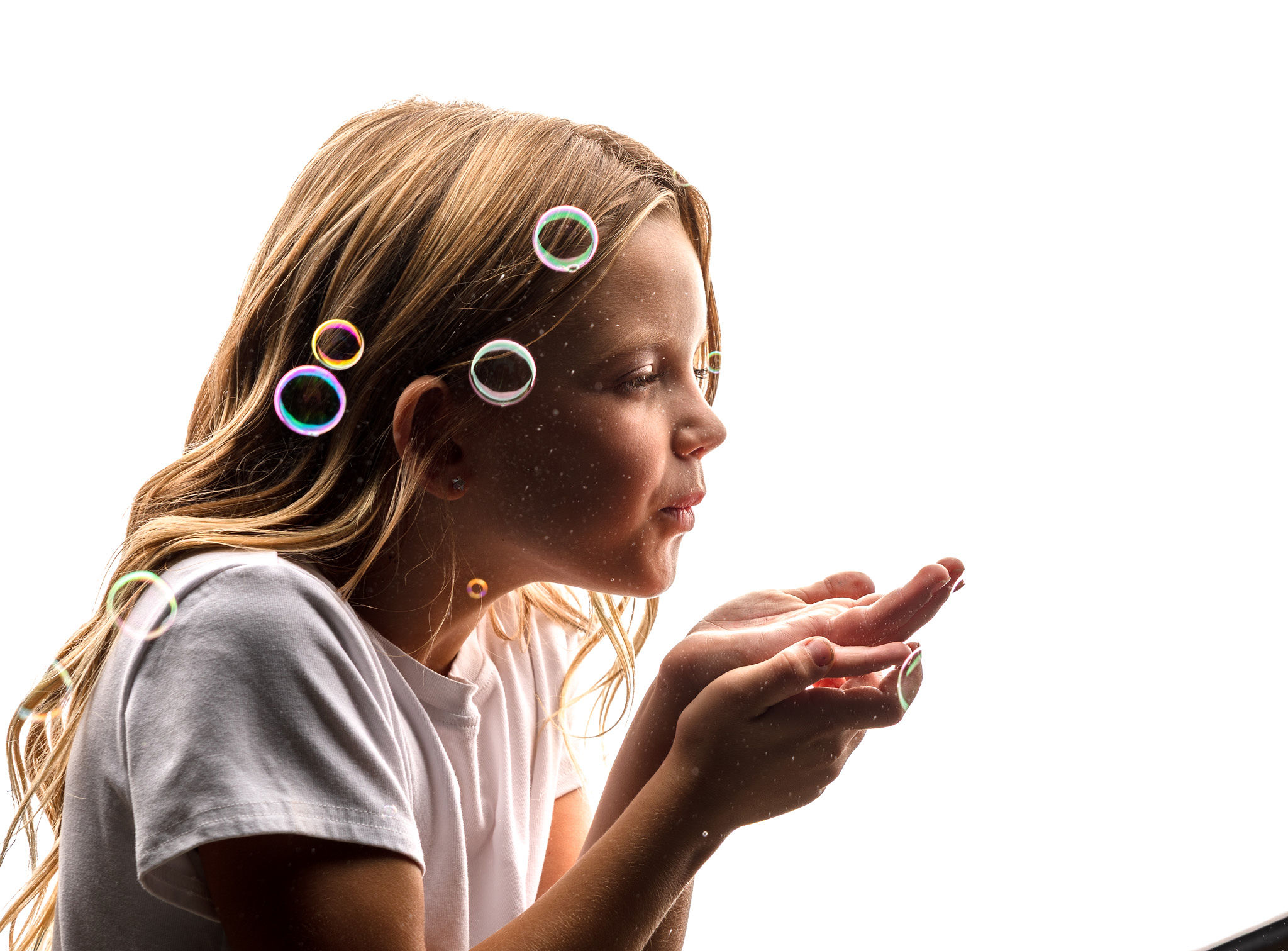 Little girl blowing bubbles.