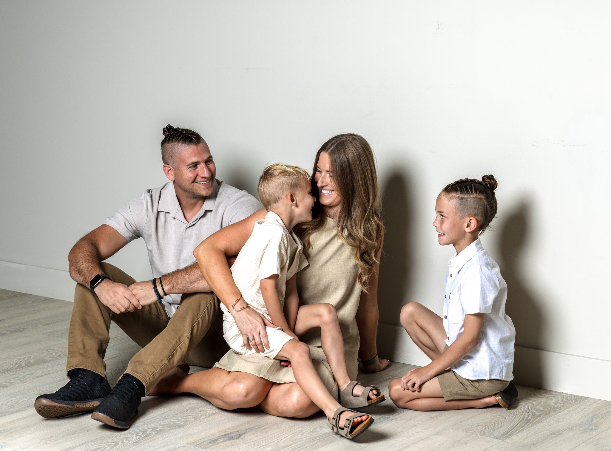 Family of 4 being goofy on floor.