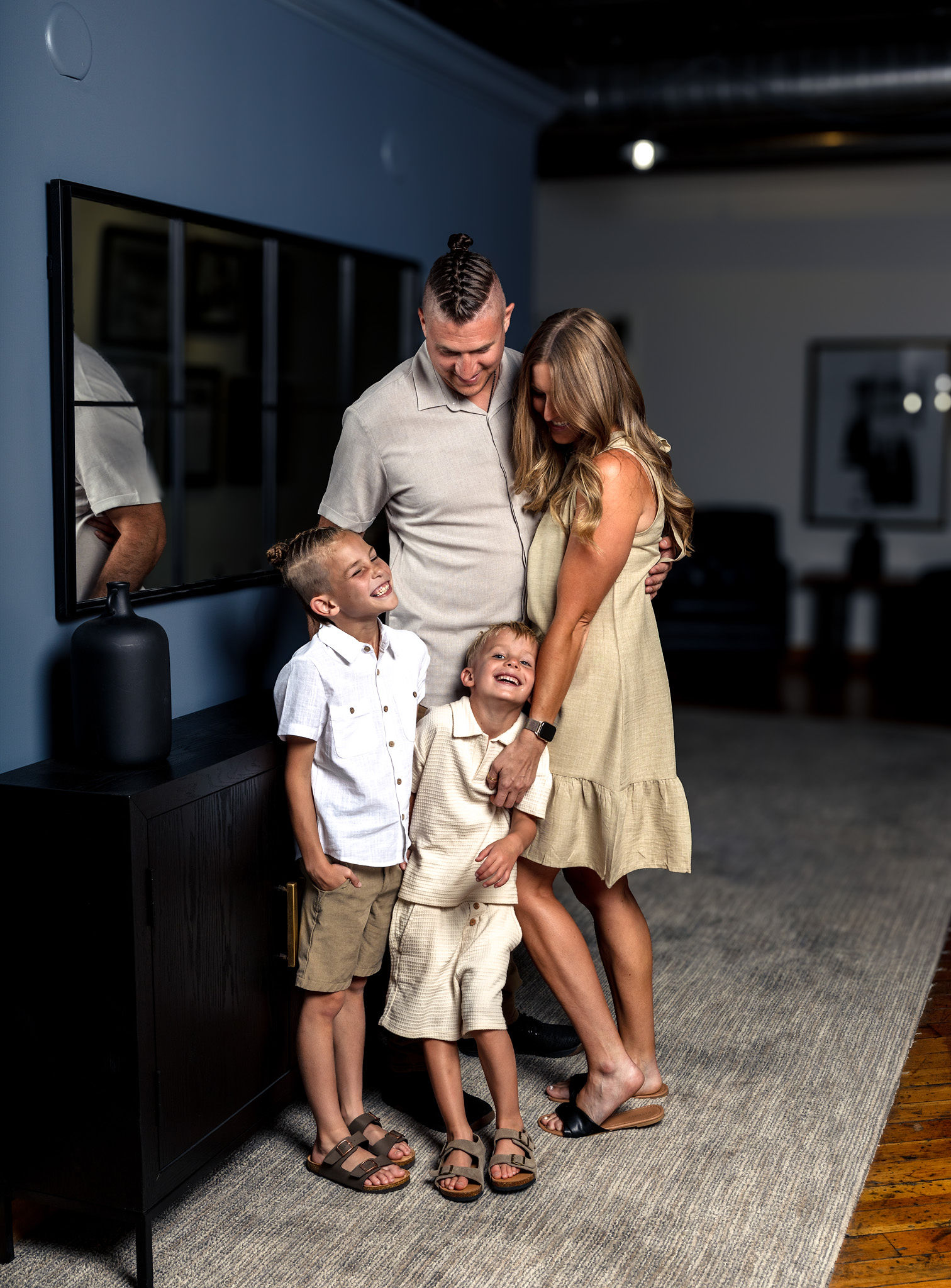 Family of 4 on blue wall with goofy boys.