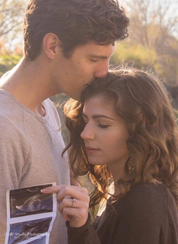 Close portrait of a couple with ultrasound photos in golden light